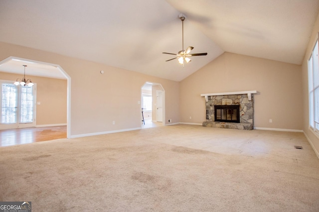 unfurnished living room with a fireplace, carpet, ceiling fan with notable chandelier, and lofted ceiling