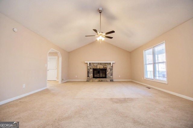 unfurnished living room with ceiling fan, light colored carpet, lofted ceiling, and a fireplace