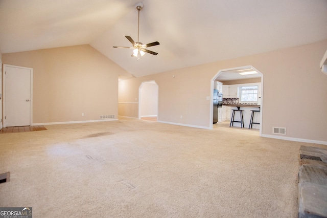 unfurnished living room with ceiling fan, light colored carpet, and lofted ceiling