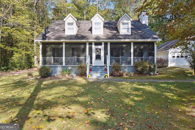 cape cod house with a sunroom, an outdoor structure, and a front yard