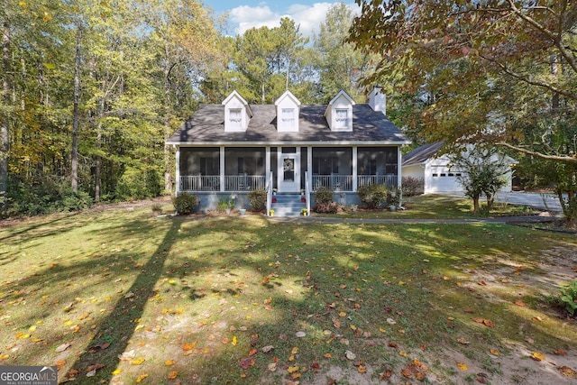 cape cod home with a sunroom, a garage, an outdoor structure, and a front lawn