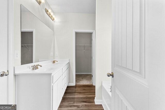 bathroom with a bath, hardwood / wood-style flooring, and vanity