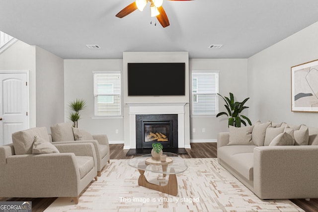 living room with light hardwood / wood-style floors, a wealth of natural light, and ceiling fan