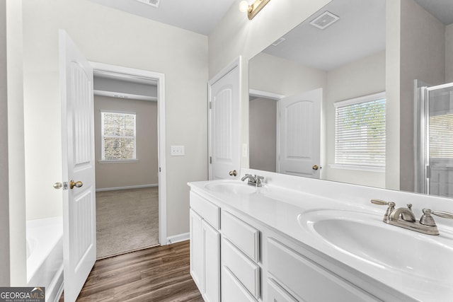 bathroom with a tub to relax in, hardwood / wood-style floors, and vanity