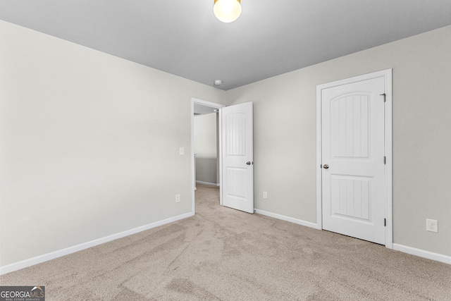 unfurnished bedroom featuring light carpet