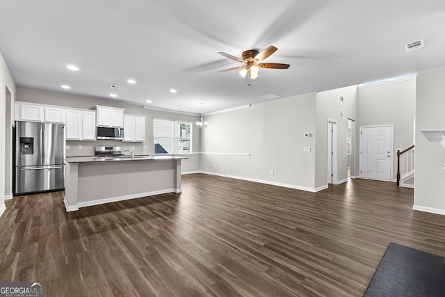 kitchen featuring ceiling fan with notable chandelier, white cabinetry, stainless steel appliances, an island with sink, and dark hardwood / wood-style floors