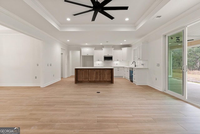 kitchen with a tray ceiling, stainless steel microwave, and ceiling fan