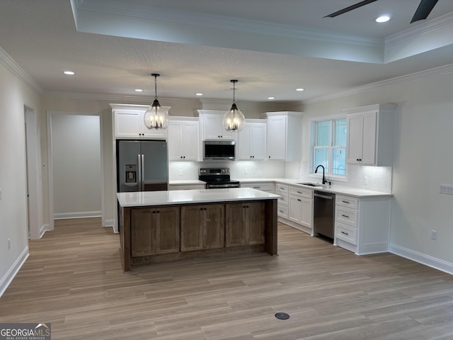 kitchen with white cabinets, light wood-style flooring, appliances with stainless steel finishes, and a sink