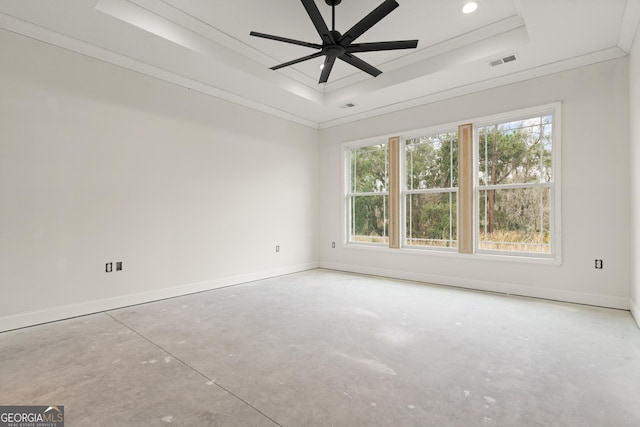 empty room featuring a wealth of natural light, a raised ceiling, visible vents, and crown molding