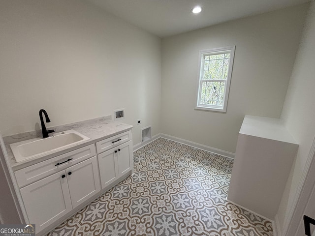 clothes washing area featuring electric dryer hookup, visible vents, washer hookup, a sink, and baseboards