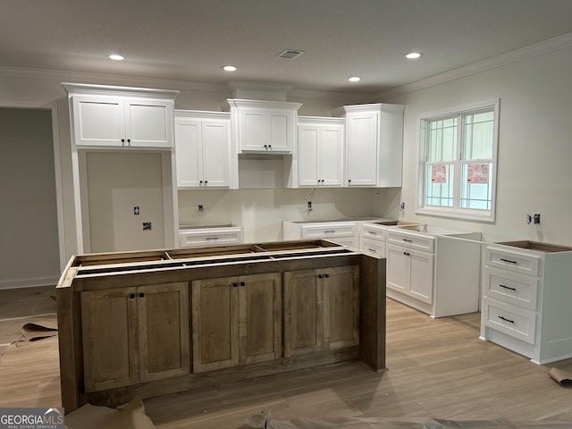 kitchen featuring light hardwood / wood-style flooring, a center island, and white cabinets