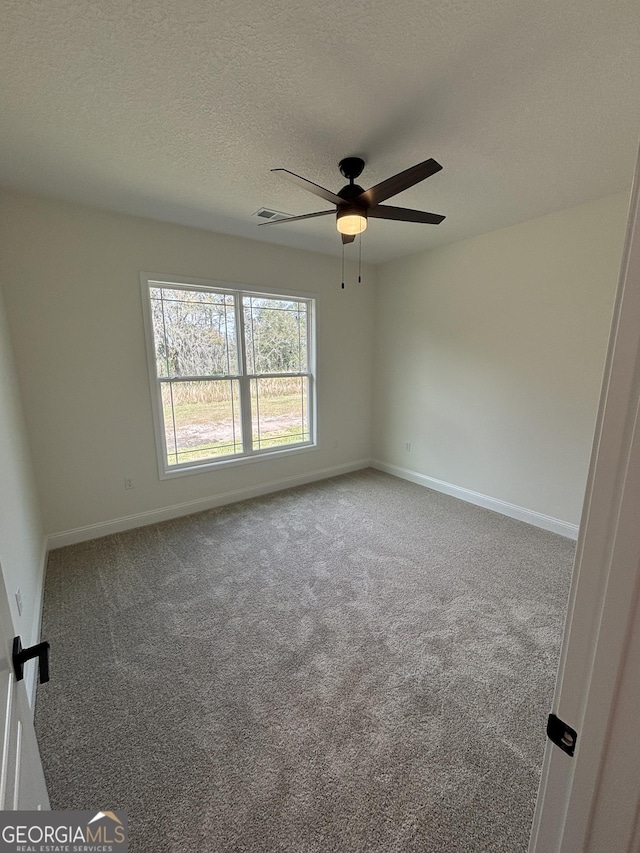 unfurnished room with visible vents, baseboards, carpet flooring, a textured ceiling, and a ceiling fan