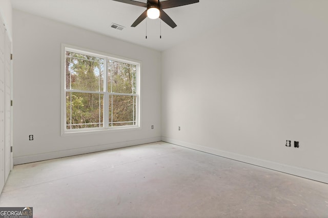 spare room featuring baseboards, concrete floors, visible vents, and a healthy amount of sunlight