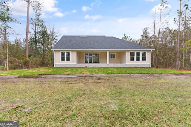 back of property featuring a yard and a shingled roof