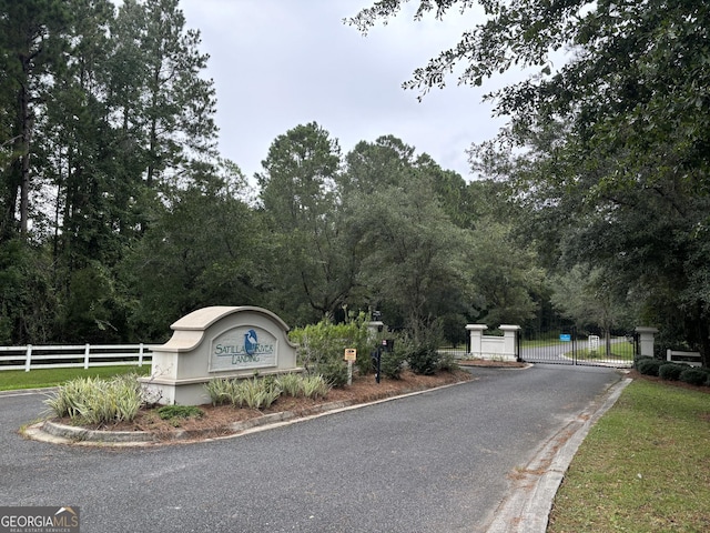 view of street with curbs, a gated entry, and a gate