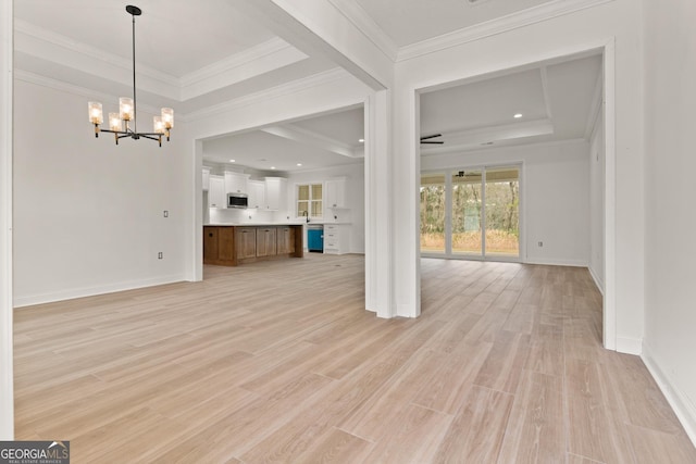 unfurnished living room featuring a tray ceiling, light wood-style floors, and a notable chandelier