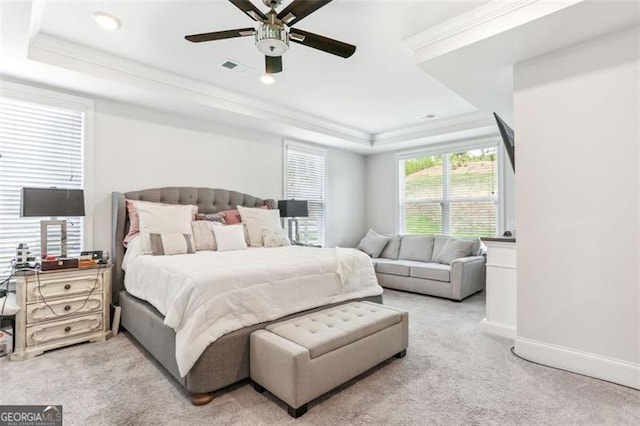 bedroom featuring a raised ceiling, ceiling fan, light colored carpet, and ornamental molding