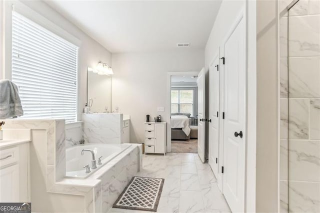 bathroom with tiled bath and vanity