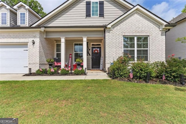 view of front of property with a porch, a garage, and a front yard