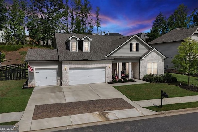 view of front of home with a garage and a lawn