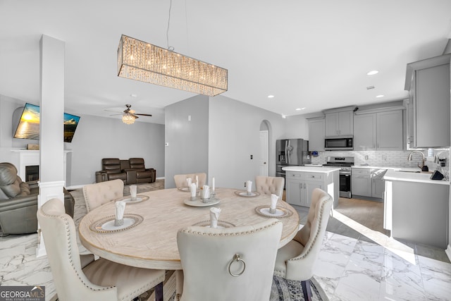 dining area with ceiling fan and sink