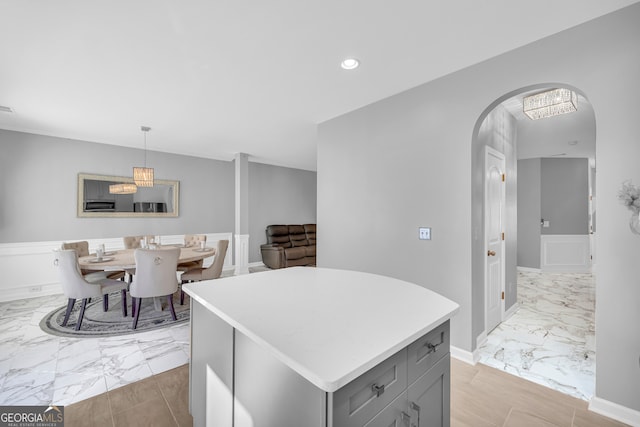 kitchen with gray cabinetry, a kitchen island, and pendant lighting