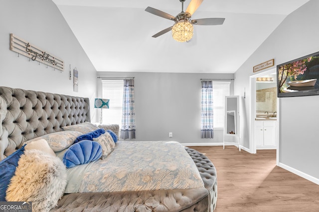 bedroom with vaulted ceiling, ceiling fan, connected bathroom, and wood-type flooring