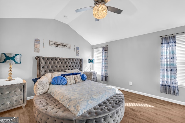 bedroom with ceiling fan, hardwood / wood-style floors, and vaulted ceiling