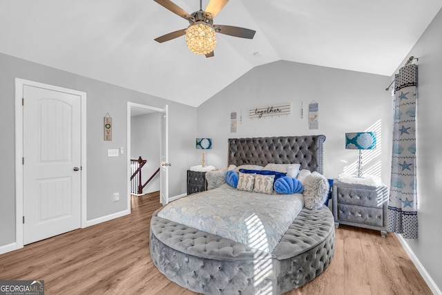 bedroom with ceiling fan, hardwood / wood-style flooring, and vaulted ceiling