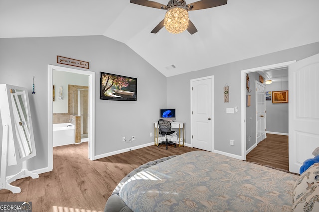 bedroom with ceiling fan, light hardwood / wood-style floors, connected bathroom, and vaulted ceiling