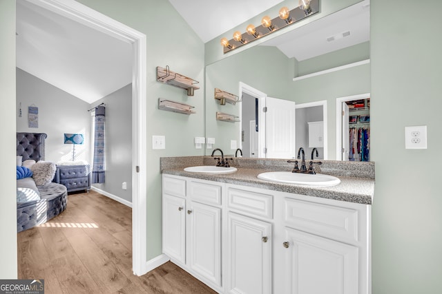 bathroom featuring vaulted ceiling, hardwood / wood-style flooring, and vanity