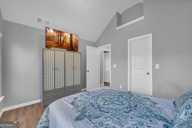 bedroom featuring light hardwood / wood-style flooring and high vaulted ceiling