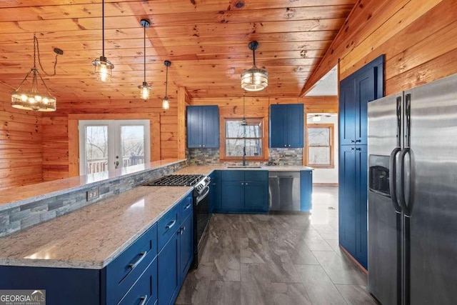 kitchen with blue cabinets, pendant lighting, vaulted ceiling, and appliances with stainless steel finishes