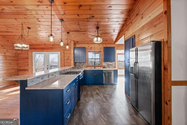 kitchen with appliances with stainless steel finishes, tasteful backsplash, decorative light fixtures, wooden ceiling, and wood walls