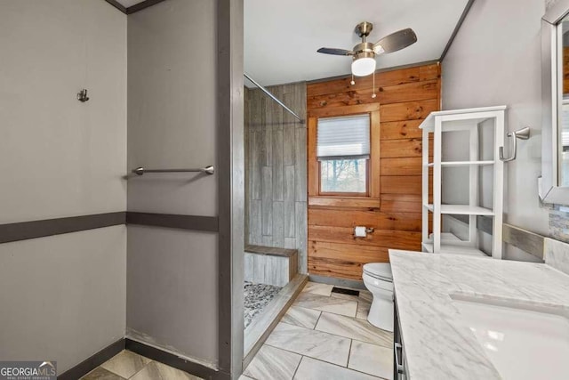 bathroom featuring vanity, wooden walls, ceiling fan, and walk in shower