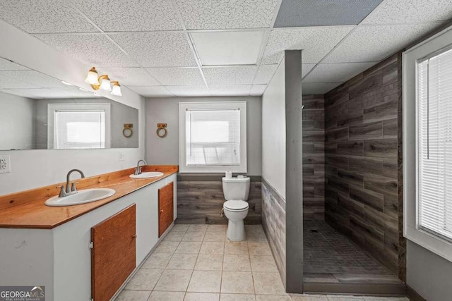 bathroom featuring tile patterned flooring, a shower, toilet, a paneled ceiling, and vanity