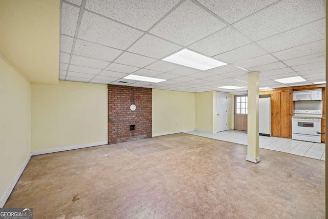 basement featuring light carpet, a drop ceiling, white fridge, and a brick fireplace