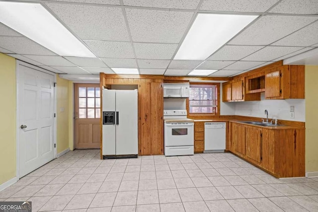 kitchen featuring a paneled ceiling, white appliances, and sink