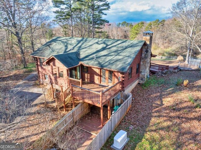 rear view of house featuring a wooden deck