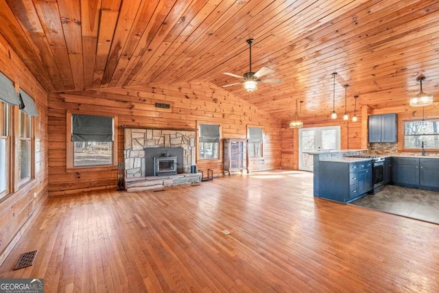 unfurnished living room with lofted ceiling, light hardwood / wood-style floors, a healthy amount of sunlight, and sink