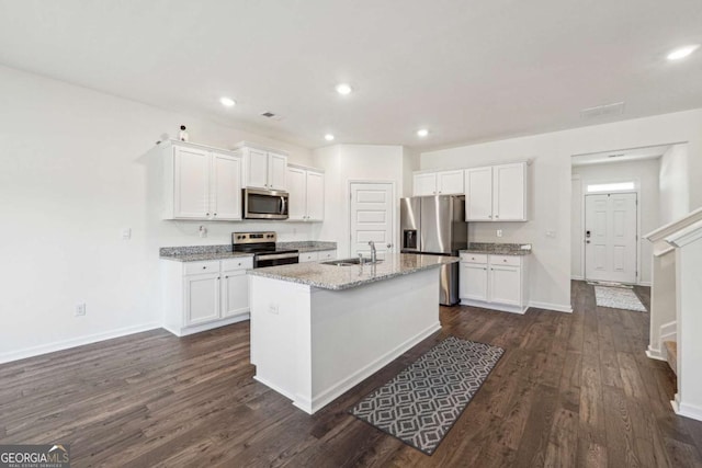 kitchen featuring white cabinets, sink, an island with sink, and appliances with stainless steel finishes