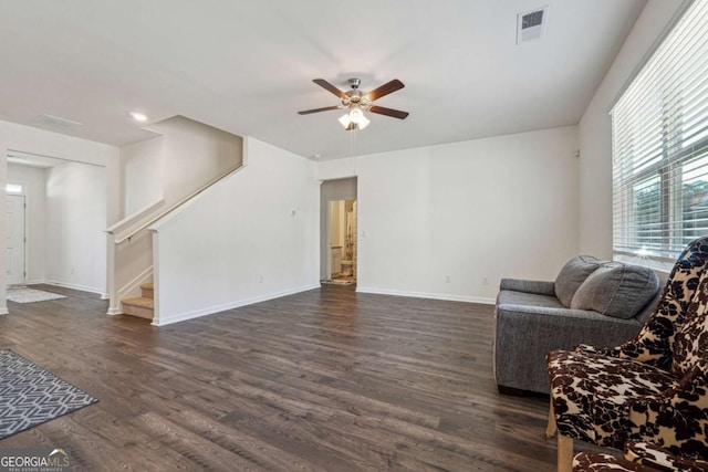 living room featuring dark hardwood / wood-style floors and ceiling fan