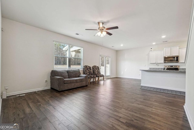 living room with ceiling fan and dark hardwood / wood-style flooring