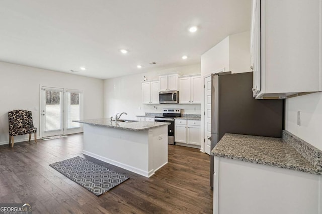 kitchen featuring light stone countertops, stainless steel appliances, sink, a center island with sink, and white cabinets