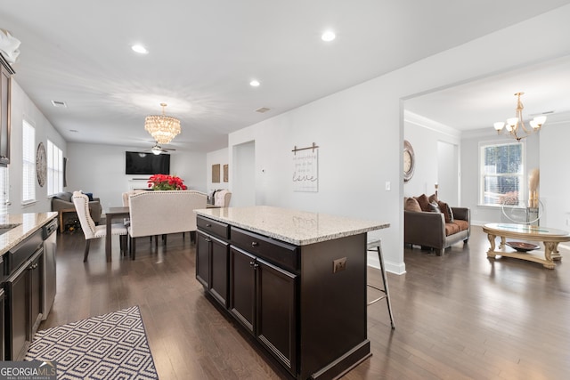 kitchen with a kitchen bar, pendant lighting, a kitchen island, and a chandelier