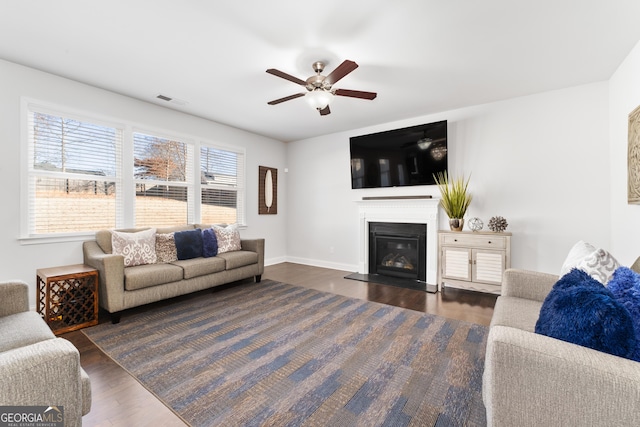 living room featuring ceiling fan and dark hardwood / wood-style flooring