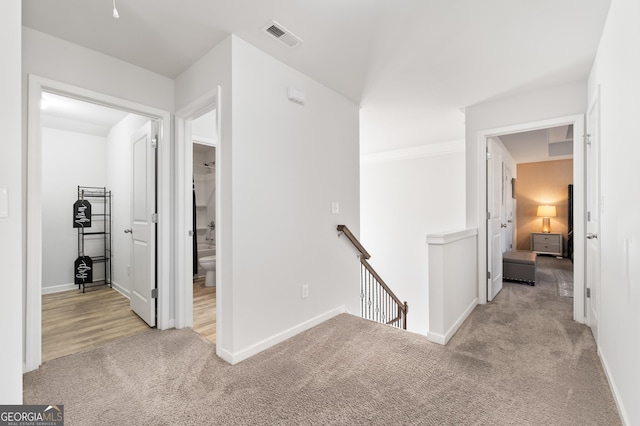 hallway featuring light colored carpet