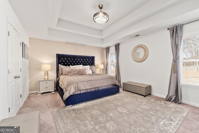 bedroom featuring a raised ceiling and carpet flooring