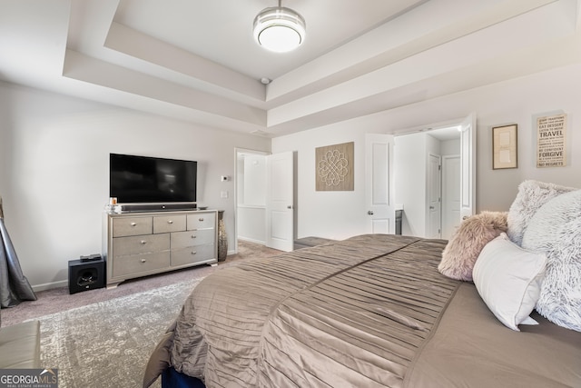 bedroom with a raised ceiling and carpet flooring