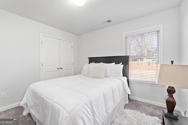 bedroom featuring multiple windows, light carpet, and a closet